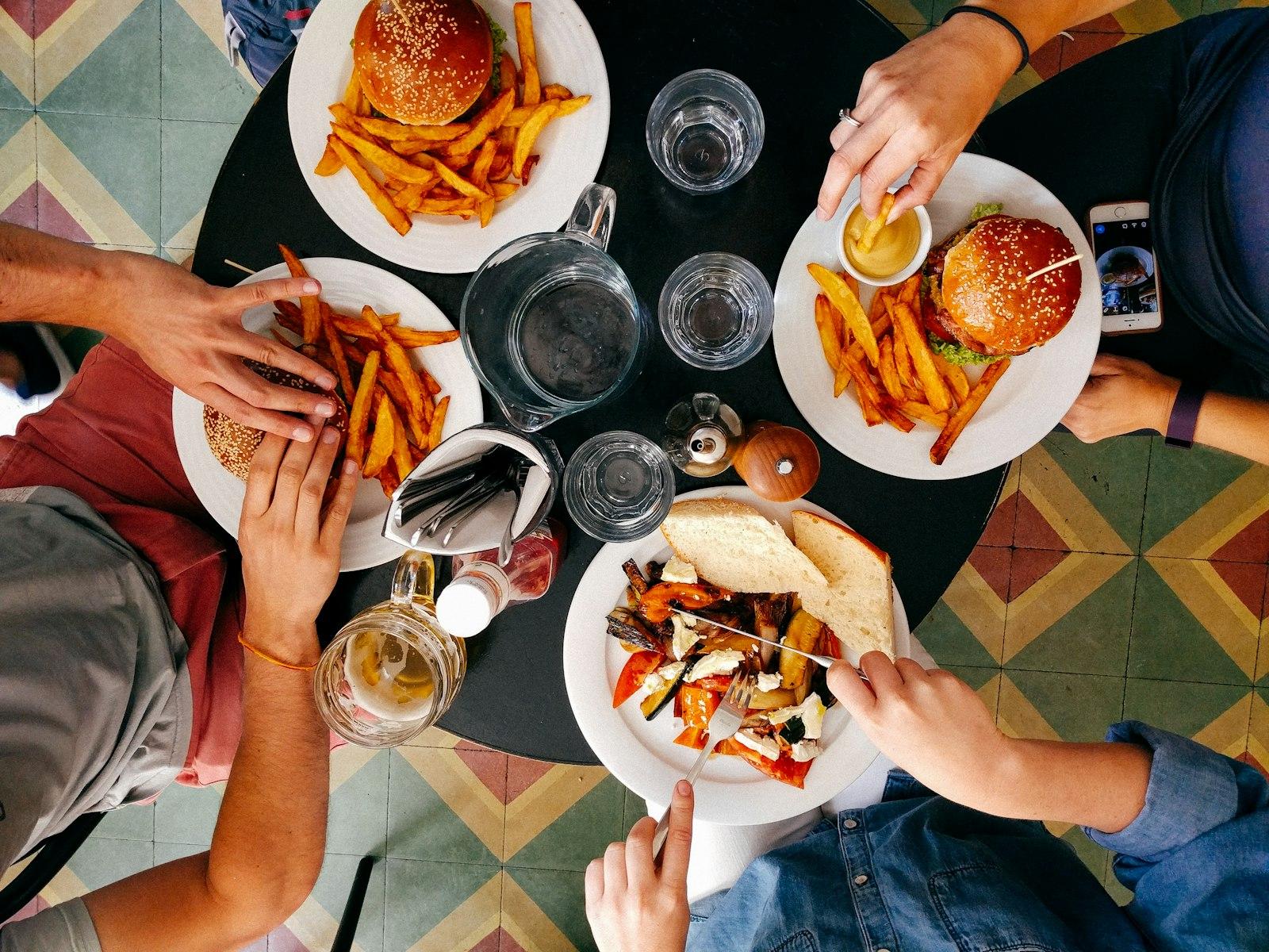 Friends sharing burgers and fries around a table